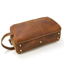 Load image into Gallery viewer, The Wanderer Toiletry Bag | Genuine Leather Toiletry Bag in brown leather with handle and rivet details, perfect for travel organization.
