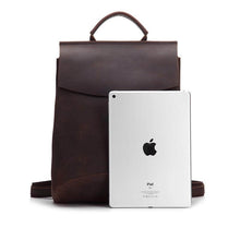 Load image into Gallery viewer, The Gyda Backpack | Vintage Leather Travel Backpack shown with an iPad for scale, showcasing storage capability and design.
