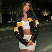Charger l&#39;image dans la galerie, Woman wearing a stylish black and yellow patchwork vegan leather jacket on a night out in an urban setting.
