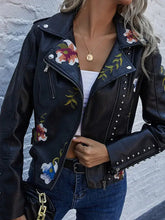 Cargar imagen en el visor de la galería, Woman wearing a floral print faux leather jacket with studded details, combining punk rock style with romantic elegance.
