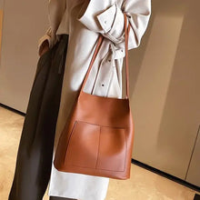 Cargar imagen en el visor de la galería, Luxury vegan leather women&#39;s shoulder bag with large capacity, soft texture, worn by model, showcasing elegance and practicality.
