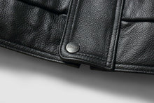 Load image into Gallery viewer, Close-up of REED Men&#39;s genuine leather bomber jacket showing detailed texture and branded button, showcasing craftsmanship.
