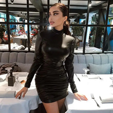 Load image into Gallery viewer, Woman wearing a vintage PU leather dress with high neck, showcasing elegance and style in a modern dining setting.
