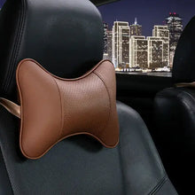 Load image into Gallery viewer, Brown PU leather car neck pillow for head pain relief on car seat at night cityscape background.

