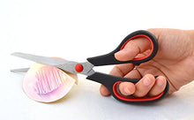 Load image into Gallery viewer, A hand using eZthings multipurpose scissors to cut paper, ideal for crafts and office projects. Durable black handle with red accents.
