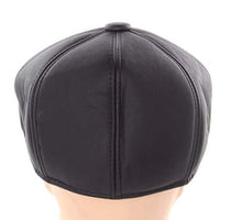 Cargar imagen en el visor de la galería, Back view of black faux leather newsboy flat cap with ear flaps, featuring a rounded design and small stiff brim.
