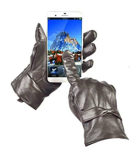 Black women's leather gloves with touchscreen capability holding a smartphone, showcasing warm lining and designer style.