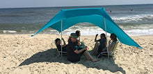 Load image into Gallery viewer, eZthings UV Light Sun Shade Protection Beach Shelter with sandbag anchors set up on sandy beach, offering shade to a group of people.

