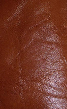 Load image into Gallery viewer, Close-up of luxurious REED sheepskin leather hide, soft and durable, showcasing a rich brown color and textured antique finish.
