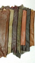 Load image into Gallery viewer, Various REED leather hides in earthy hues, showcasing whole skins sized 7 to 10 SF, soft and durable for crafting unique art pieces.
